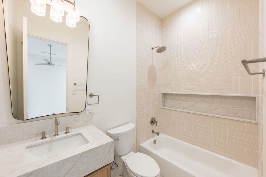 Clean lines meet tactile finishes in this thoughtfully curated bathroom. A tailored hex mosaic floor grounds the room, while layered neutrals, satin fixtures, and a custom vanity composition create a calming backdrop for slow mornings and unhurried evenings.