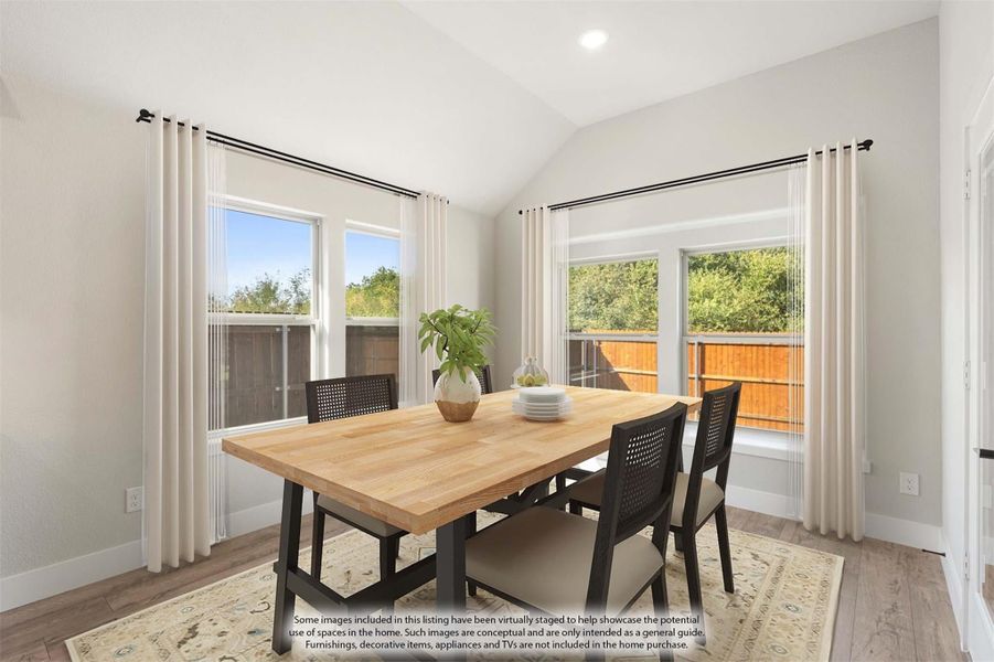 Dining room with vaulted ceiling, wood table, dark chairs, and large windows with white curtains