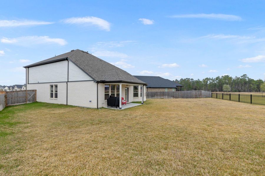 Spacious backyard with a covered patio, ideal for outdoor activities and relaxation. The area is fenced, providing privacy and security. Perfect for families or entertaining. Spacious backyard with a covered patio, ideal for outdoor activities and relaxation. The area is fenced, providing privacy and security. Perfect for families or entertaining.