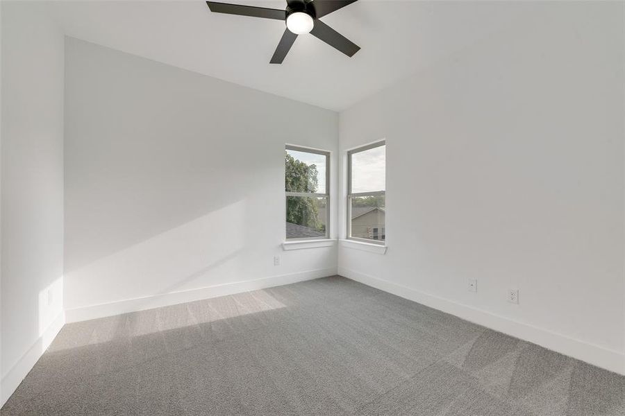 Carpeted empty room with baseboards and ceiling fan Carpeted empty room with baseboards and ceiling fan