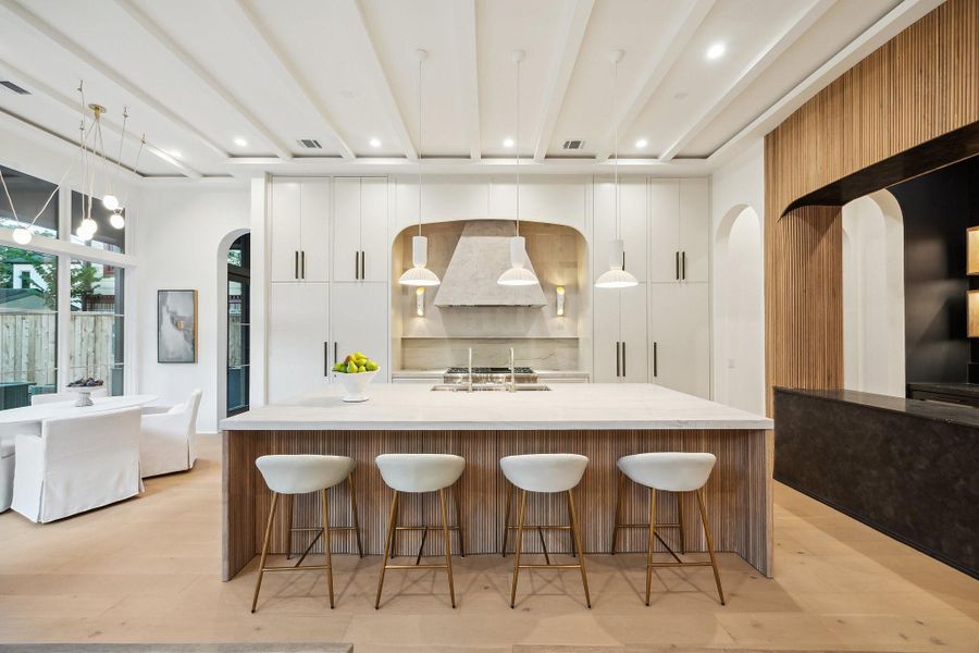 Stunning Island Kitchen with Honed Slab Quartzite Counter, Stained Oak Ribbed Front and Side Returns. Tray Ceiling with Painted Boxed Beams with Three Pendant Lights. Inset Cabinet Doors and Drawers with Soft Close. Stunning Island Kitchen with Honed Slab Quartzite Counter, Stained Oak Ribbed Front and Side Returns. Tray Ceiling with Painted Boxed Beams with Three Pendant Lights. Inset Cabinet Doors and Drawers with Soft Close.