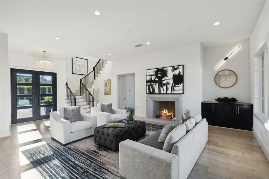 Living room featuring french doors, light wood-type flooring, and a chandelier