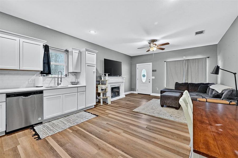 Living room with a ceiling fan, light wood finished floors, a glass covered fireplace, and recessed lighting Living room with a ceiling fan, light wood finished floors, a glass covered fireplace, and recessed lighting