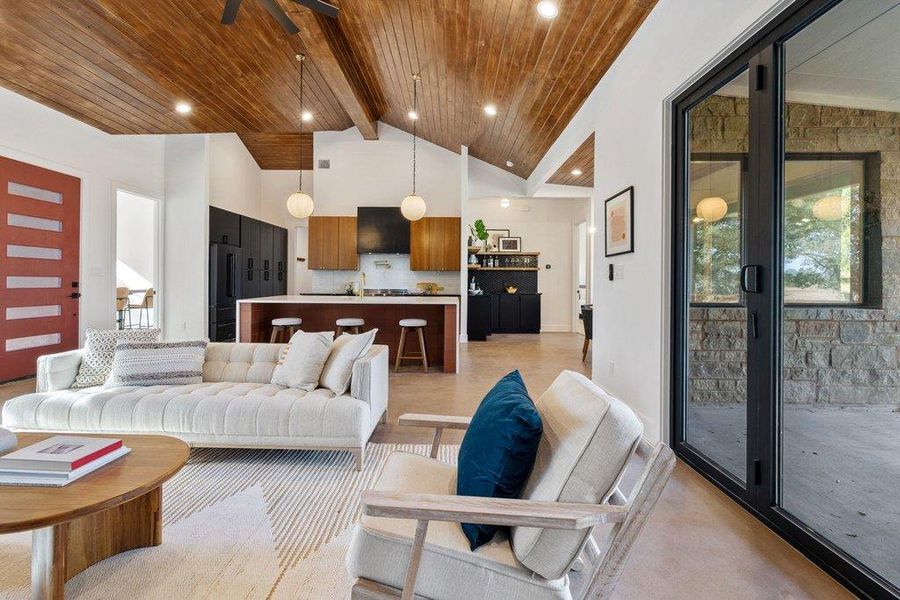 Living room with high vaulted ceiling, a wood ceiling with exposed beams, and ceiling fan