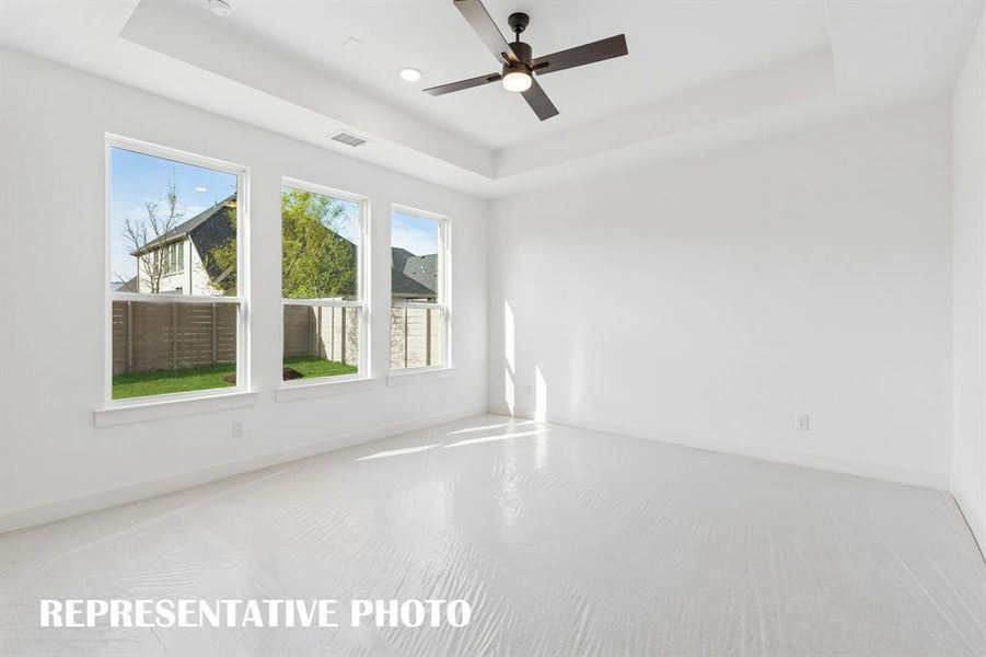 Located at the rear of the home for additional privacy, this dream owner's suite features high ceilings, a wall of windows overlooking the back yard and plush carpeting.  REPRESENTATIVE PHOTO