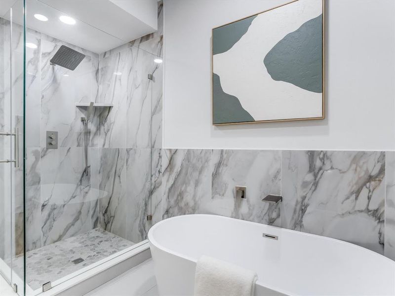 Primary bathroom with freestanding soaking tub with wall-mounted fixtures Primary bathroom with freestanding soaking tub with wall-mounted fixtures