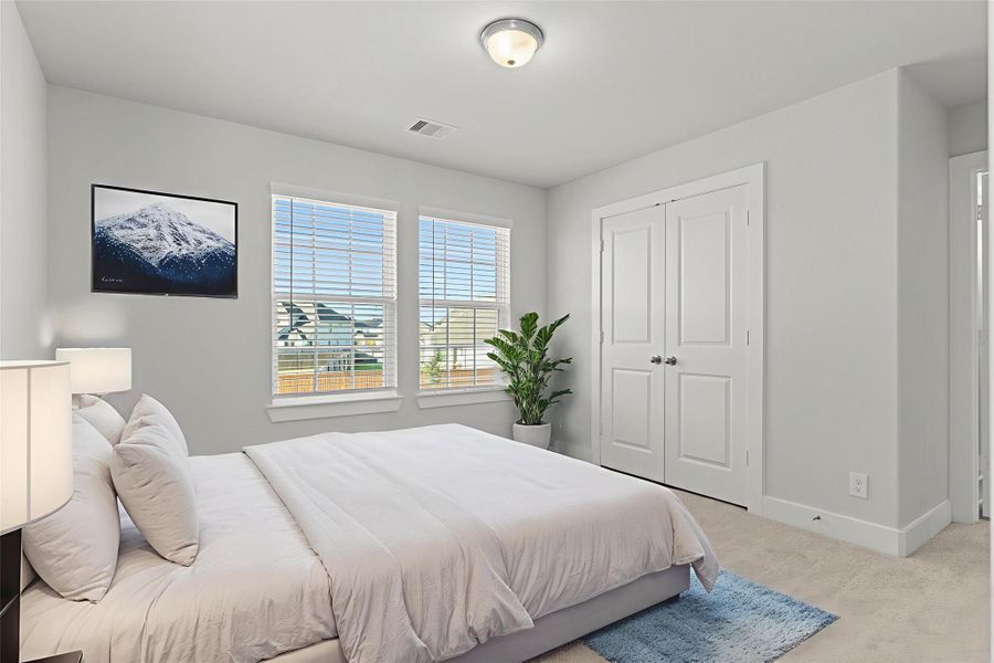 Virtually staged — A secondary bedroom upstairs features large windows and a generous layout with a spacious closet—ideal for family members or guests who’ll appreciate comfort and privacy.