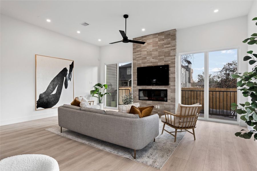 Centered around a sleek linear fireplace, the living room balances clean architecture with inviting warmth. Natural light and refined finishes create a setting that feels both elevated and easy to live in.