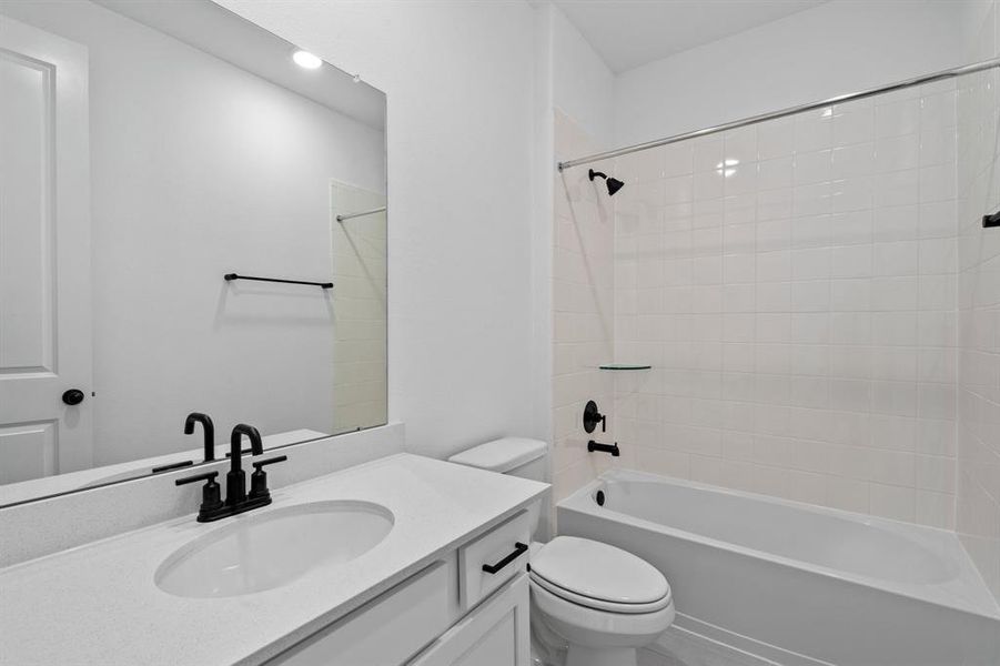 The secondary bath features tile flooring, white cabinetry and light countertops and a shower/tub combo. Perfect for accommodating any visiting family and friends.