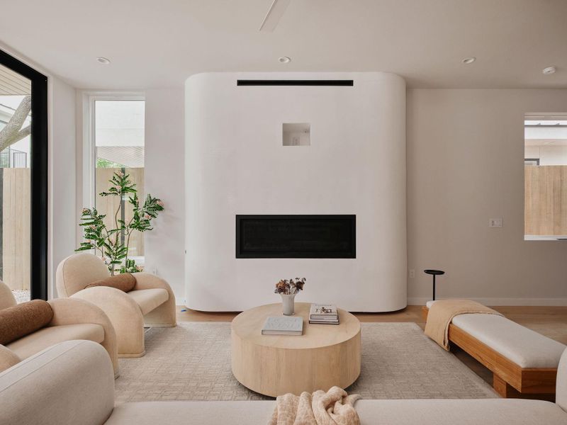 Contemporary living area featuring a built-in fireplace, recessed lighting, and wood-finish flooring