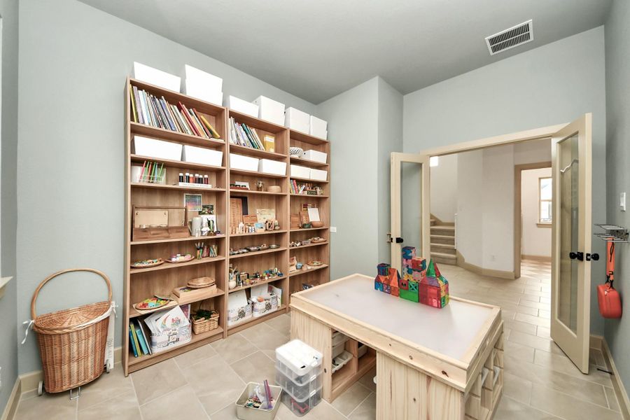 This first floor office features custom French doors, which is being used as a playroom.