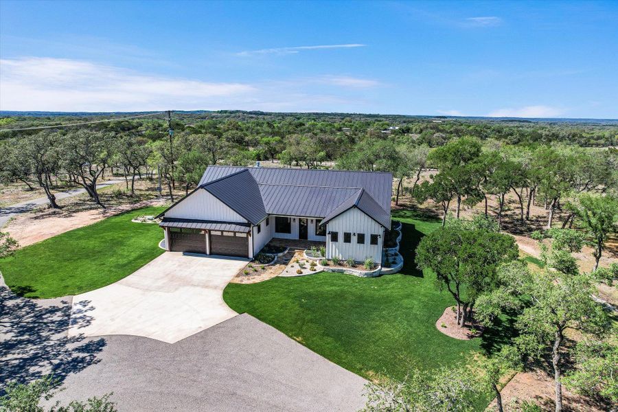View of front of property with driveway, a front lawn, a garage, and a standing seam roof