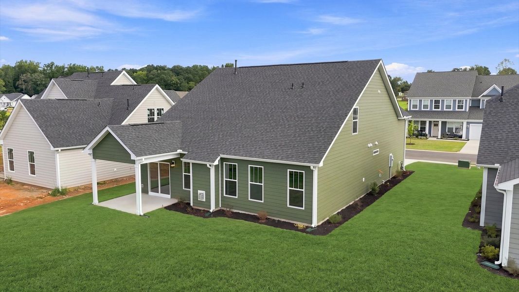 Vibrant rear outdoor space featuring a covered porch and exceptional craftsmanship at Wells Crossing