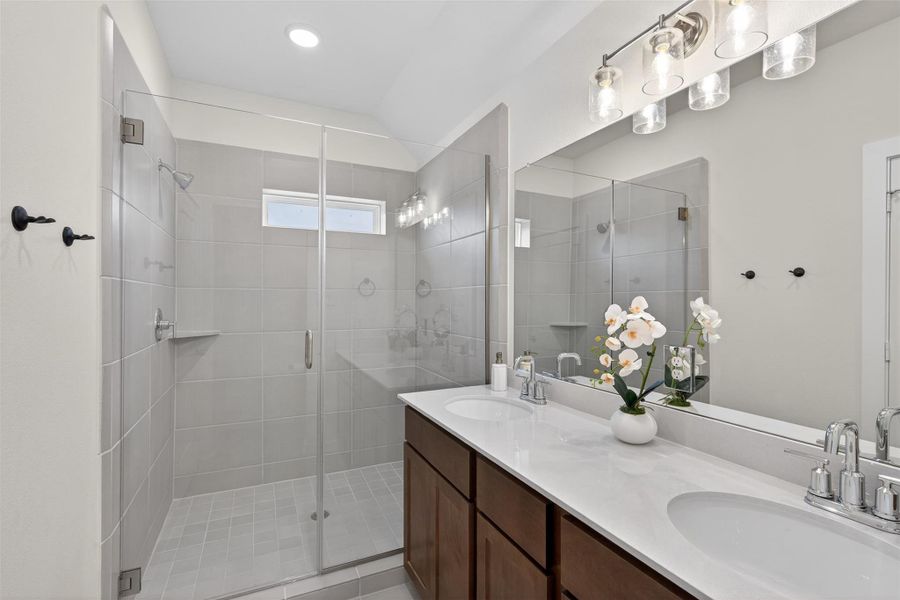 Elegant walk-in shower with glass enclosure paired with a generous dual vanity, creating a spa-inspired bathroom experience. Elegant walk-in shower with glass enclosure paired with a generous dual vanity, creating a spa-inspired bathroom experience.