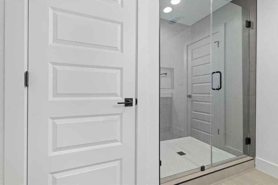 Bathroom with a shower stall, recessed lighting, and tile patterned floors Bathroom with a shower stall, recessed lighting, and tile patterned floors