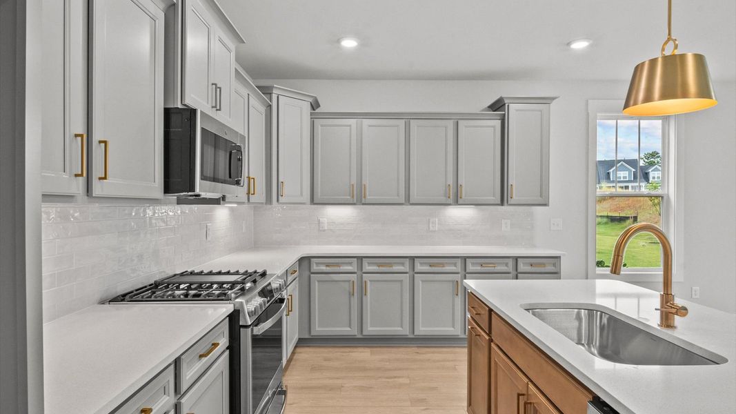 Highly skilled craftsmanship shines in this modern kitchen with pendant lighting and a central island focal point