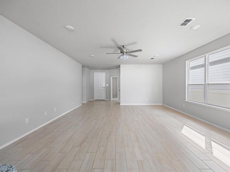 Unfurnished living room with light wood-style flooring and ceiling fan Unfurnished living room with light wood-style flooring and ceiling fan