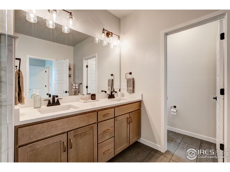 Upgraded cabinets and hardware, quartz countertops, large tile flooring and separate room for the toilet
