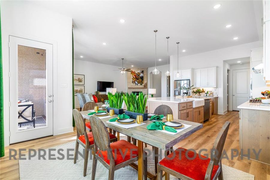 Dining room featuring a large fireplace, a ceiling fan, light wood-style floors, and recessed lighting Dining room featuring a large fireplace, a ceiling fan, light wood-style floors, and recessed lighting