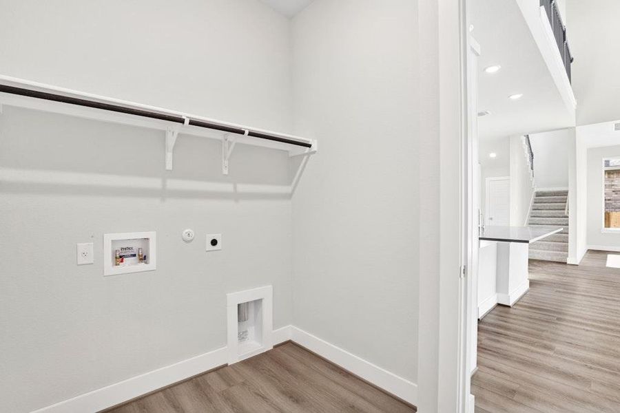 Laundry area with gas dryer hookup, light wood-type flooring, recessed lighting, electric dryer hookup, and hookup for a washing machine Laundry area with gas dryer hookup, light wood-type flooring, recessed lighting, electric dryer hookup, and hookup for a washing machine
