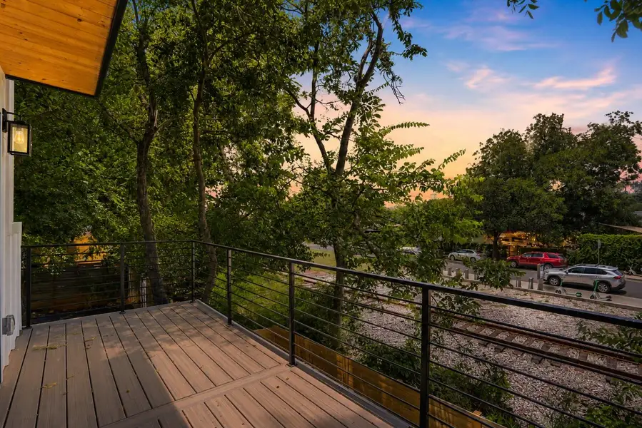 An inviting deck offers a prime spot for enjoying picturesque sunsets over the lush, tree-lined surroundings.