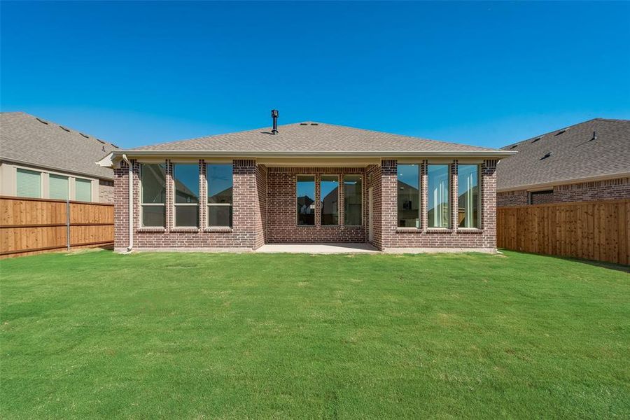 Back of house featuring a lawn and a patio area