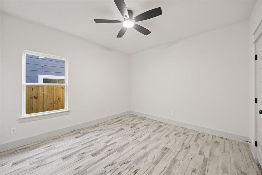 Spare room with light wood finished floors and a ceiling fan Spare room with light wood finished floors and a ceiling fan