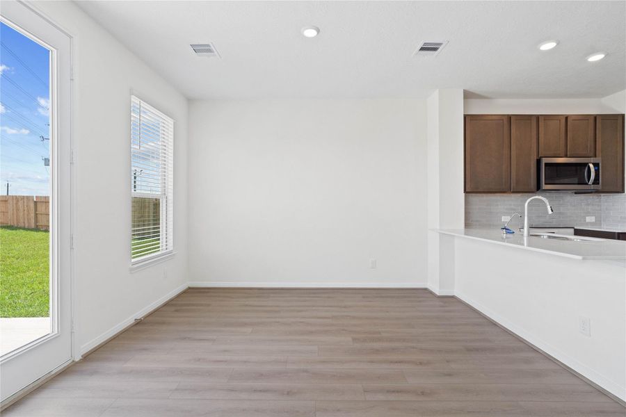 Create lasting memories around the table with family and friends in this inviting dining room! It showcases high ceilings, large window with privacy blinds, vinyl plank flooring, access door to the backyard, and recessed lighting for a warm and welcoming atmosphere. Create lasting memories around the table with family and friends in this inviting dining room! It showcases high ceilings, large window with privacy blinds, vinyl plank flooring, access door to the backyard, and recessed lighting for a warm and welcoming atmosphere.