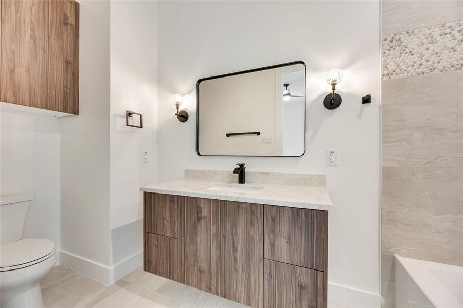Bathroom featuring vanity and a tub Bathroom featuring vanity and a tub