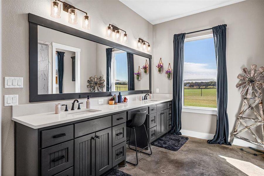 Full bathroom featuring double vanity, plenty of natural light, and concrete flooring Full bathroom featuring double vanity, plenty of natural light, and concrete flooring