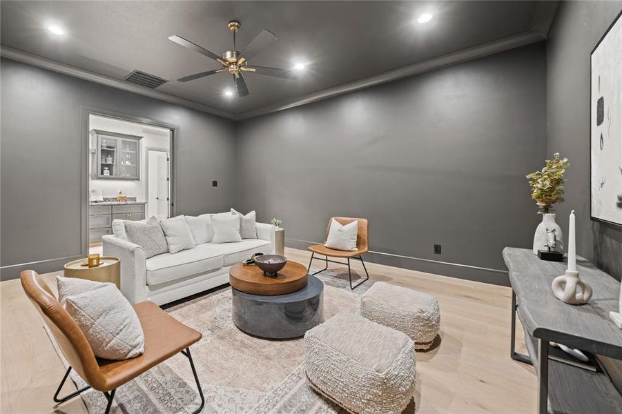 Living room with recessed lighting, wood finished floors, a ceiling fan, and ornamental molding Living room with recessed lighting, wood finished floors, a ceiling fan, and ornamental molding