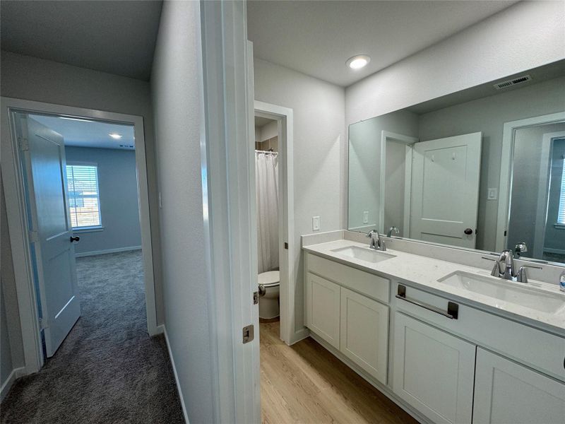 Upstairs bathroom featuring a spacious vanity with dual sinks, large mirror, and a tub/shower combination. Upstairs bathroom featuring a spacious vanity with dual sinks, large mirror, and a tub/shower combination.