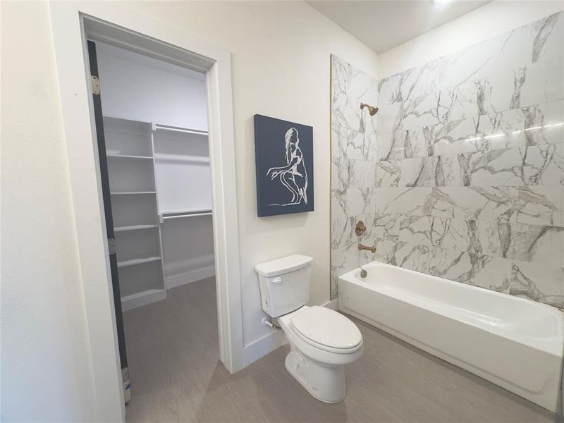 Bathroom featuring toilet, hardwood / wood-style floors, and tiled shower / bath