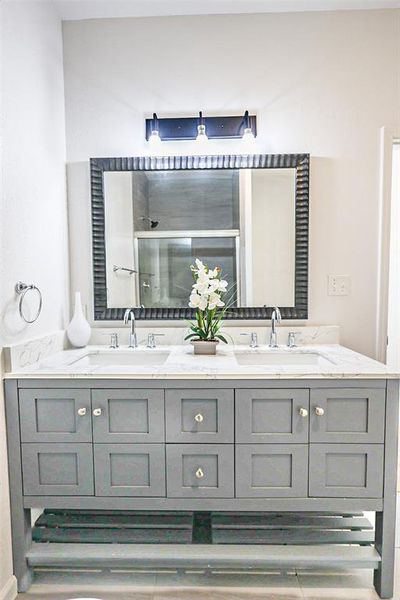 Bathroom with double vanity and a tile shower
