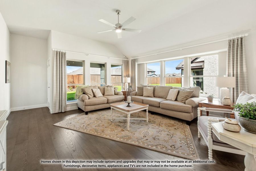 Living room with vaulted ceiling, hardwood floors, large windows, and two beige sofas around a wood coffee table. Living room with vaulted ceiling, hardwood floors, large windows, and two beige sofas around a wood coffee table.