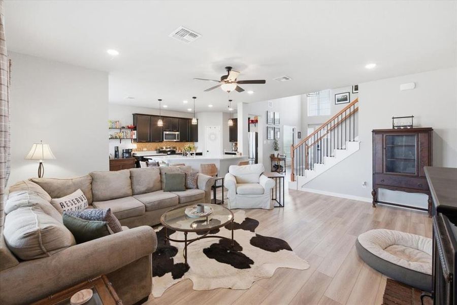 Living room with ceiling fan, light wood finished floors, and recessed LED lighting Living room with ceiling fan, light wood finished floors, and recessed LED lighting