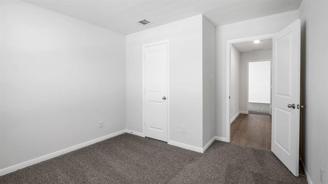Unfurnished bedroom with baseboards and dark colored carpet