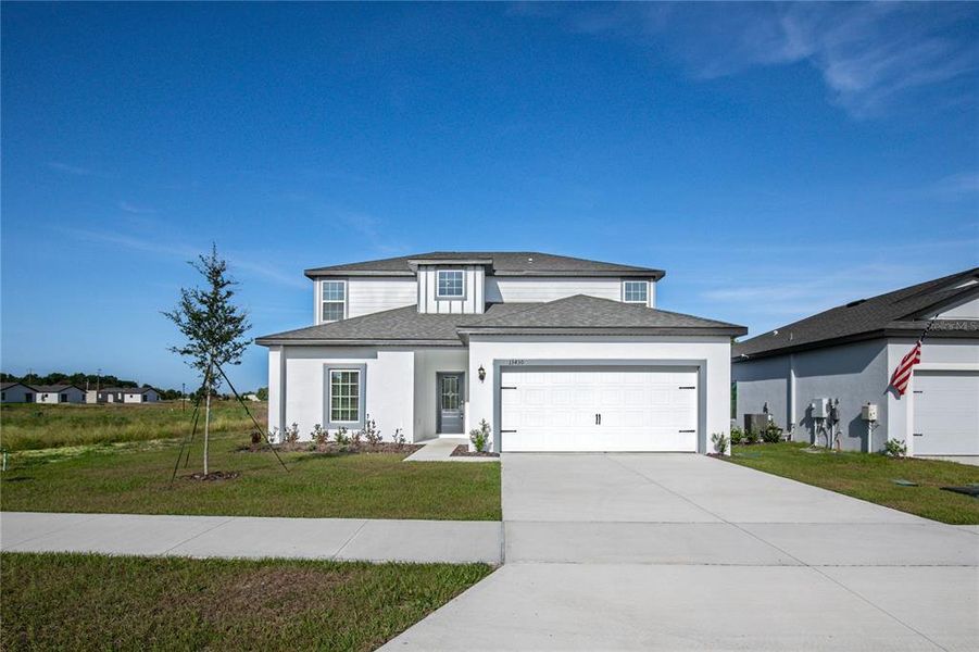 Front exterior of a new home in Tula Parc, Astatula, FL, highlighting curb appeal (Image 25).