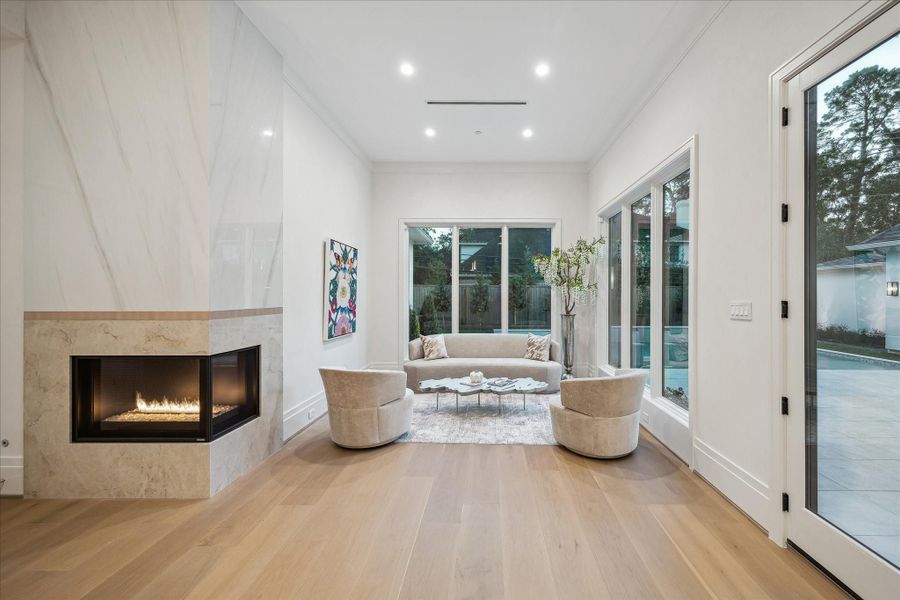 A calm, light-soaked sitting area in the primary suite, framed by tall windows that capture the pool views. A set of double French doors opens directly to the backyard, creating an elegant private escape.