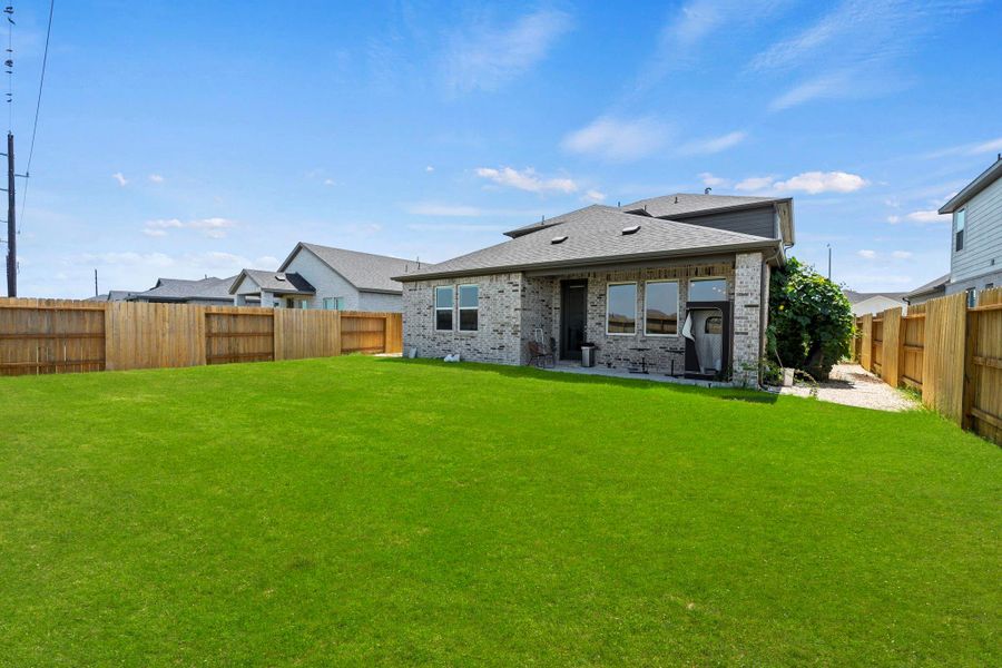 The backyard opens toward green space with no direct rear neighbors. The fenced lawn and covered patio create a clean outdoor extension of the home. The backyard opens toward green space with no direct rear neighbors. The fenced lawn and covered patio create a clean outdoor extension of the home.