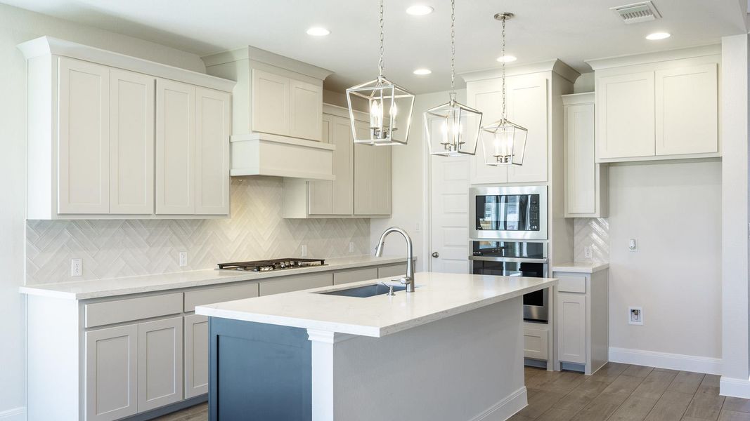 Kitchen featuring appliances with stainless steel finishes, recessed lighting, wood finished floors, a center island with sink, and decorative backsplash Kitchen featuring appliances with stainless steel finishes, recessed lighting, wood finished floors, a center island with sink, and decorative backsplash