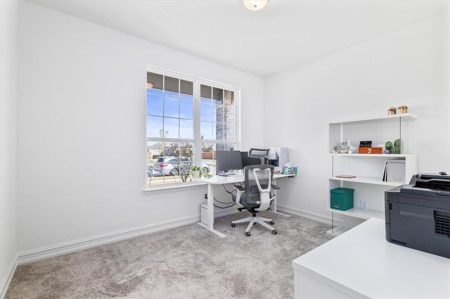 Office area with light colored carpet and baseboards