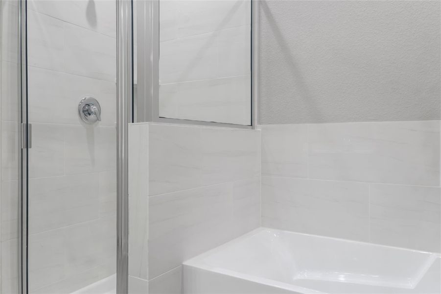 This photo showcases a modern bathroom with sleek, light-colored tiles and a glass-enclosed shower. The design is clean and contemporary, offering a fresh and inviting atmosphere.