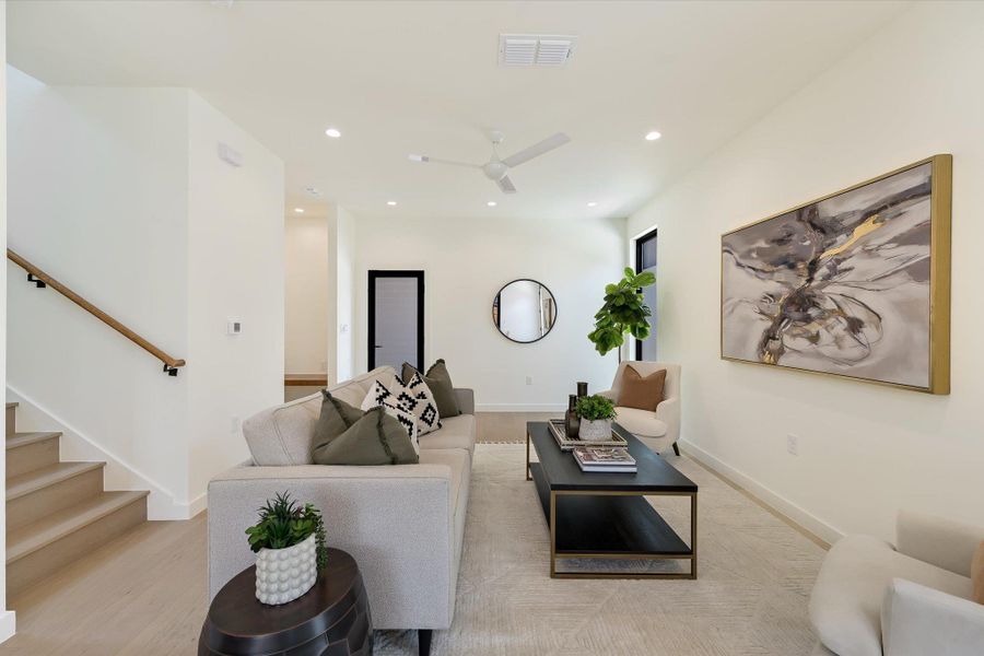Living area featuring recessed lighting, a ceiling fan, and stairs