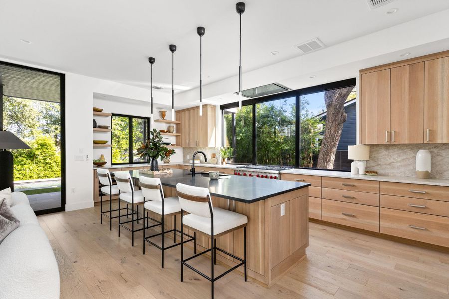 Kitchen featuring light brown cabinets, decorative backsplash, light wood finished floors, a kitchen island with sink, and recessed lighting Kitchen featuring light brown cabinets, decorative backsplash, light wood finished floors, a kitchen island with sink, and recessed lighting