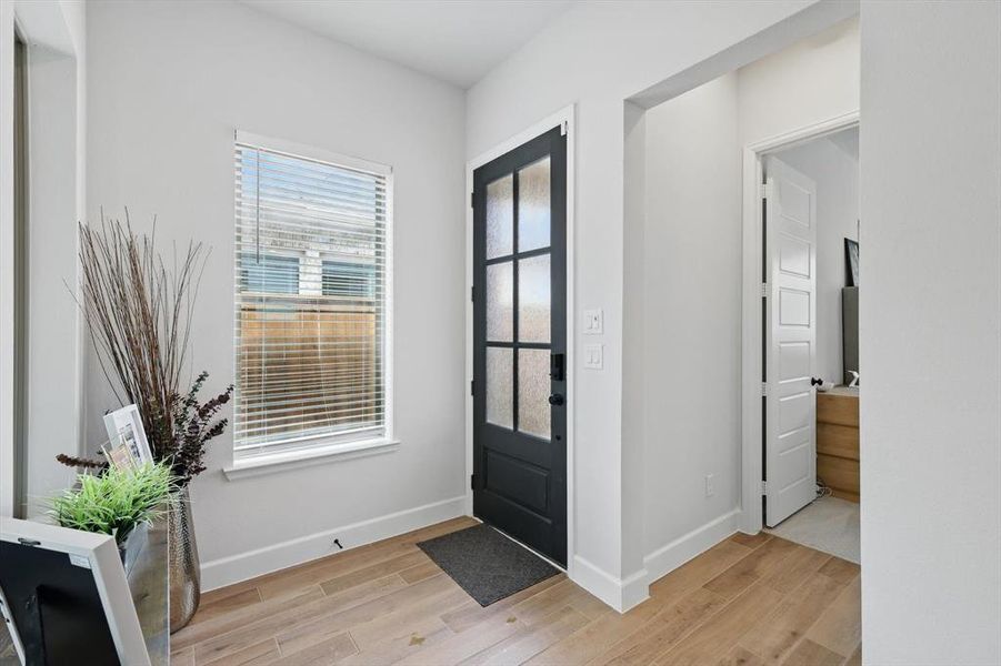 Foyer entrance with baseboards and light wood-type flooring