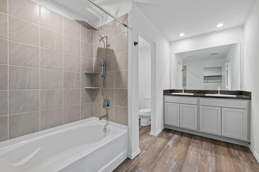 Primary bathroom with his/hers sinks and tub/shower combo.