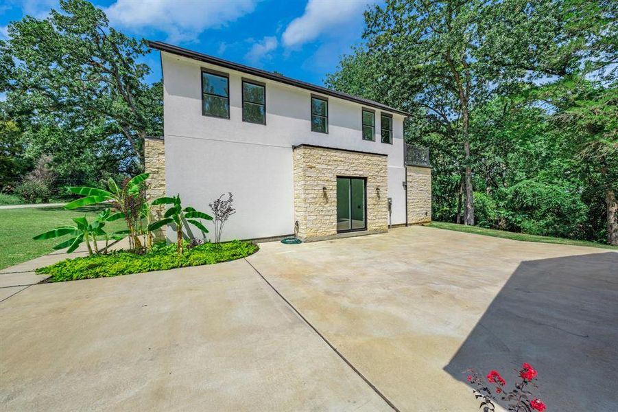 View of front facade featuring stone siding, stucco siding, and a front lawn View of front facade featuring stone siding, stucco siding, and a front lawn
