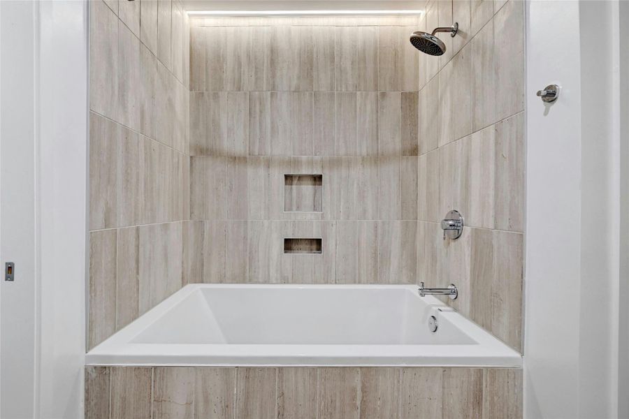 The shower and tub combo is designed with floor to ceiling tiles. The shower and tub combo is designed with floor to ceiling tiles.