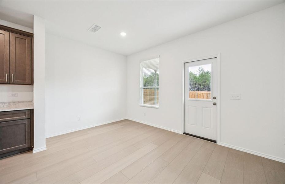 Dining nook off kitchen with large windows